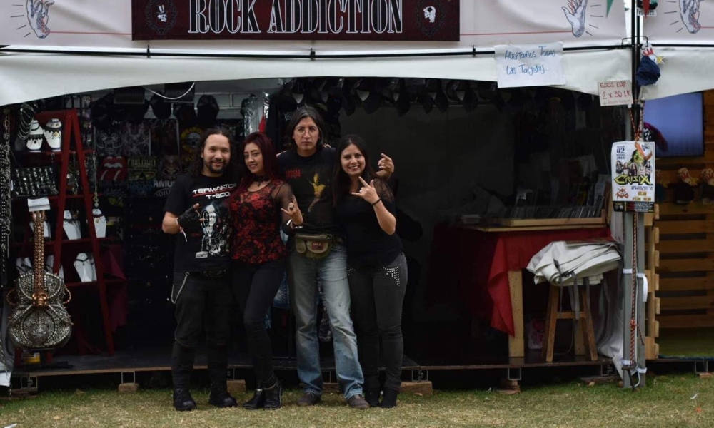 Dos hombres y dos mujeres haciendo señal de rock.