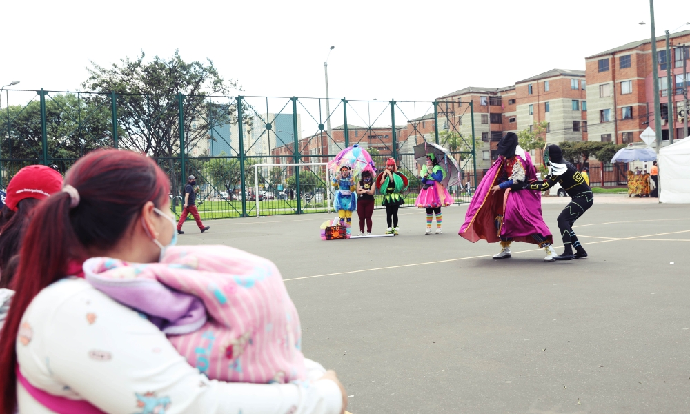 Familias disfrutando de la presentación del Programa Nidos en un parque de Bogotá