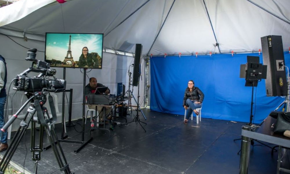 Set de grabación con una mujer posando frente a las cámaras. 