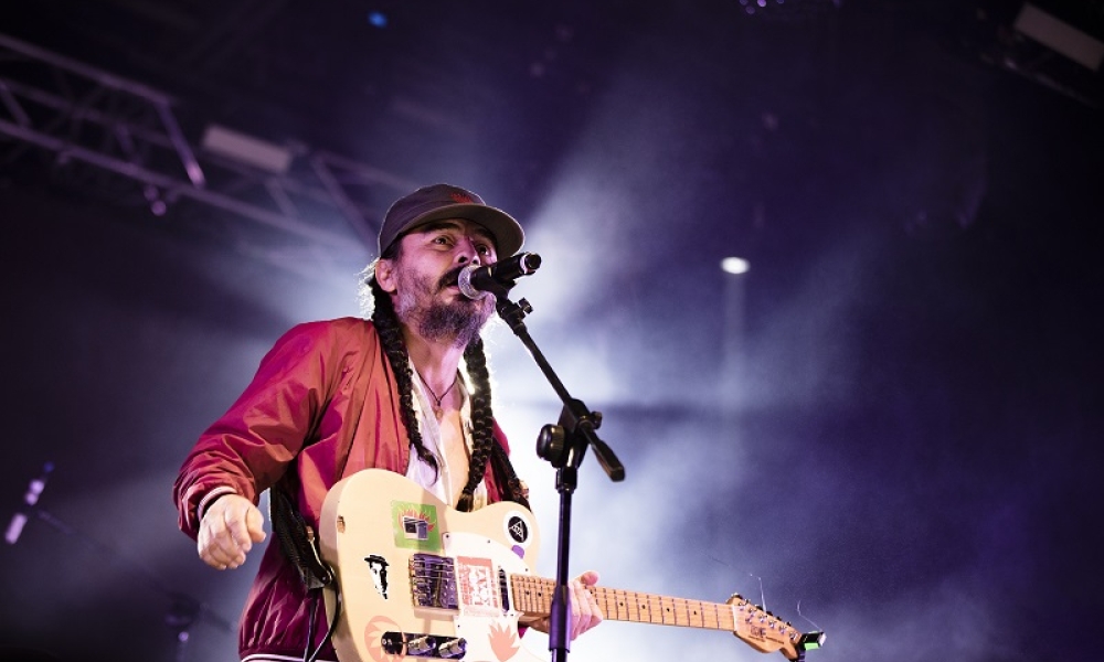 El músico Edson Velandia, tocando guitarra en una tarima 