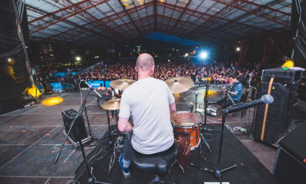 Hombre tocando bateria ante gran público