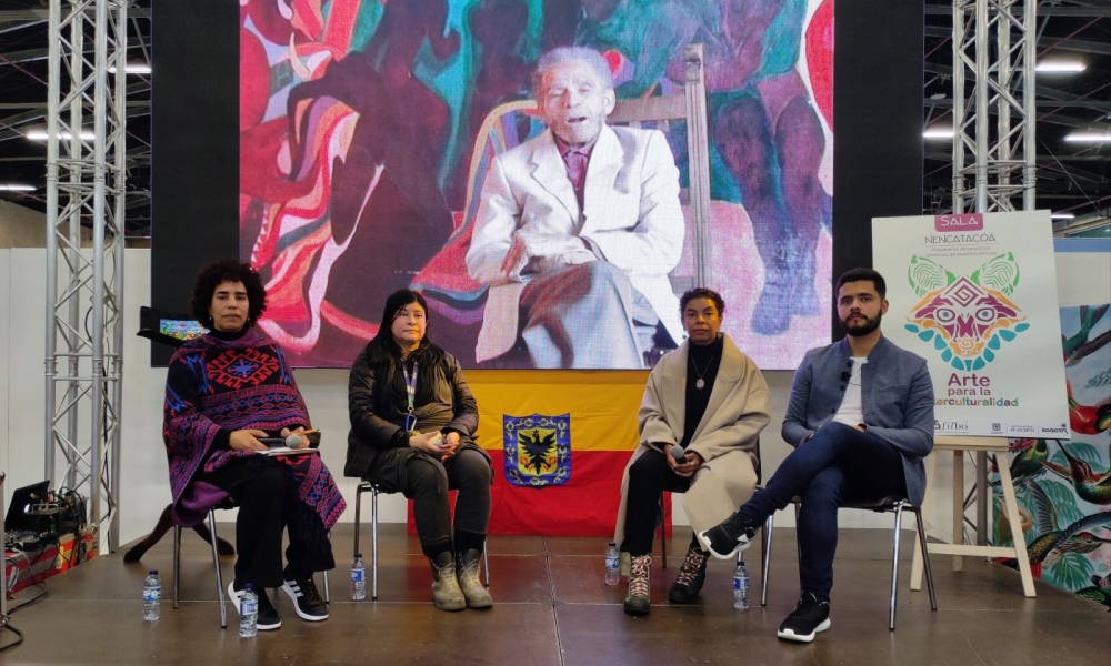 4 personas sentadas en la tarima de la sala Nencatacoa, donde se lanzó la exposición virtual