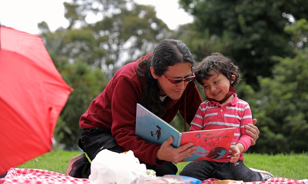 Niño en primera infancia leyendo con su papá