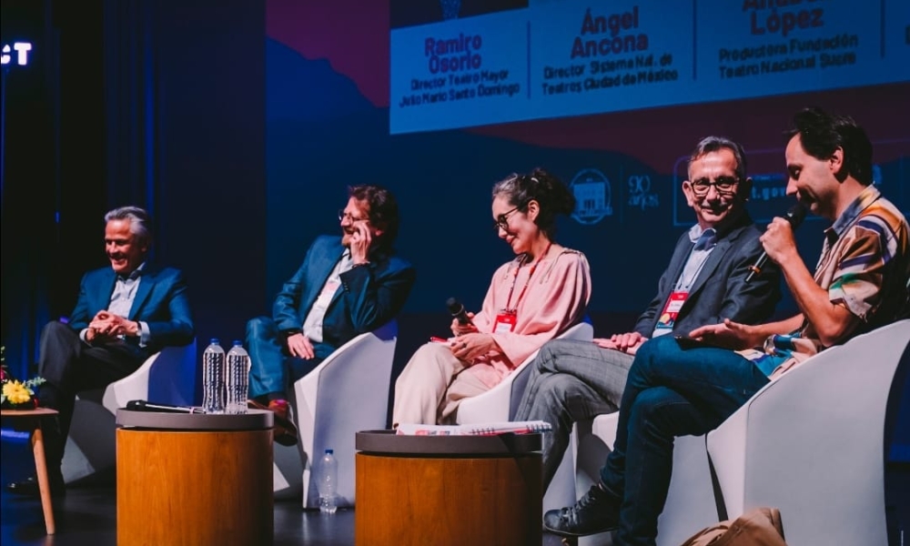 Personas sentadas en panel en un escenario