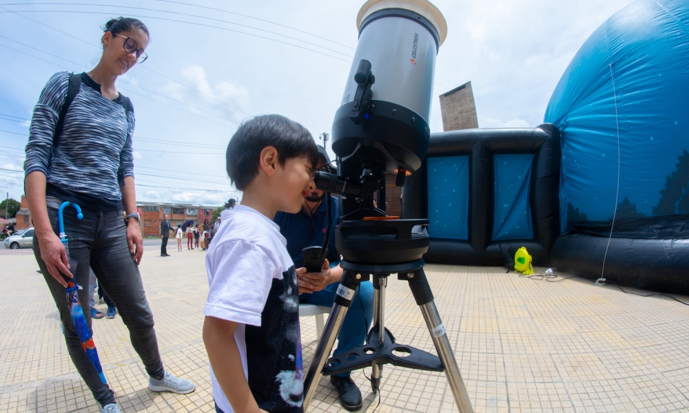 Personas observando por telescopio.