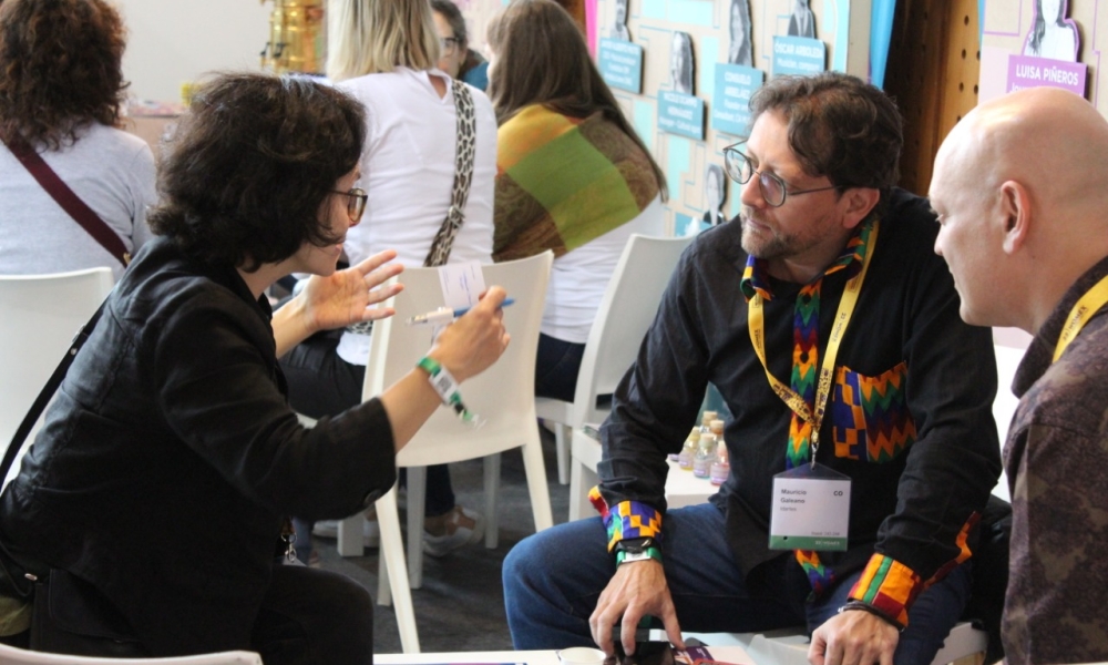 Carlos Mauricio Galeano dialoga con dos representantes de una delegación internacional en WOMEX