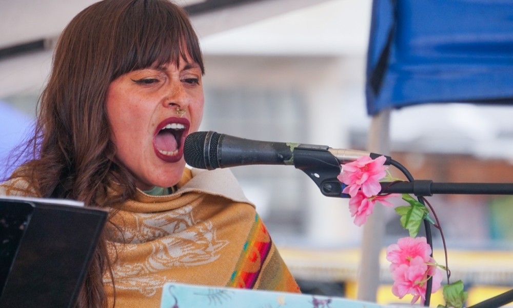 Mujer canta frente a un micrófono de día 