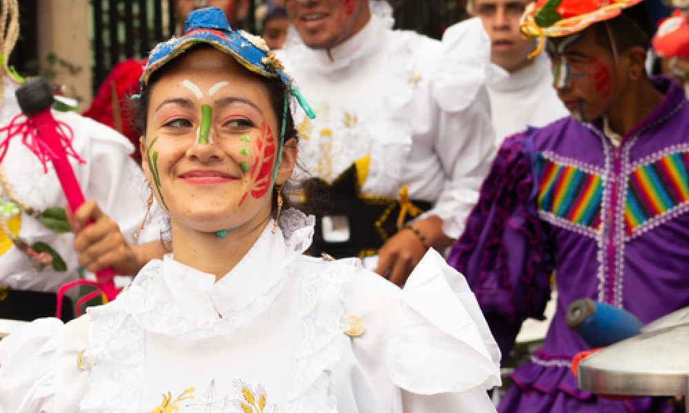 Artista mujer vestida de blanco y sonriendo 