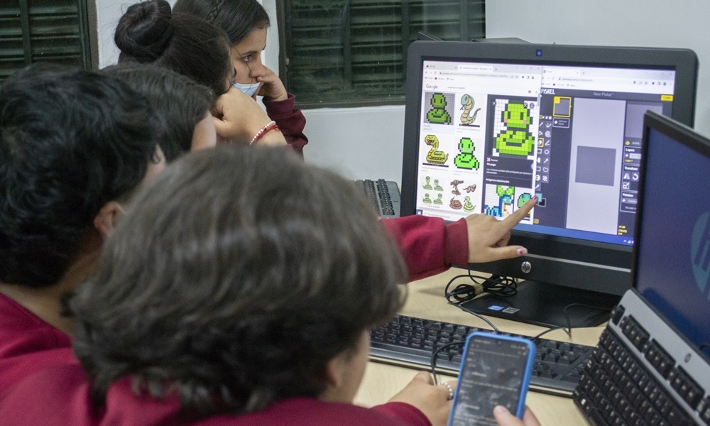 un grupo de jóvenes está frente a un computador 