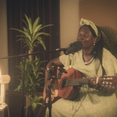 Mujer afro cantando en una sala 