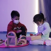 Niños jugando con piezas de madera, sentados en el piso