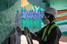 Mujer artista hace una intervención con pintura en la Zona Bajo Puente de la 170. Foto: Kadir Molano / Idartes.