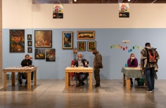 Foto de expositores en las Ferias Locales de Artes de la Candelaria sentados en mesas con sus creaciones