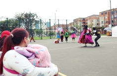 Familias disfrutando de la presentación del Programa Nidos en un parque de Bogotá