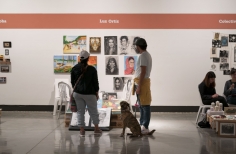 Pareja y perro observando los puestos de los artistas de las FLA en La Galería Santa Fe