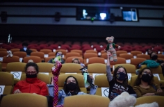 Niños y niñas sentados en la Cinemateca con títeres en las manos