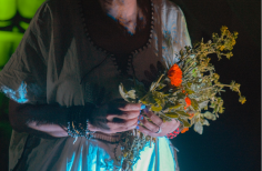 Manos de actriz sosteniendo flores.