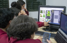 un grupo de jóvenes está frente a un computador 