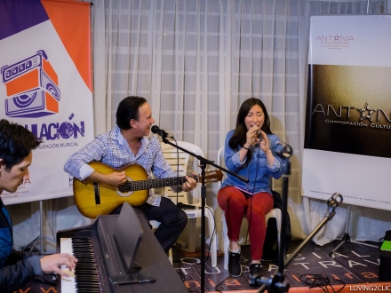 hombre y mujer sentados tocando guitarra y cantando 