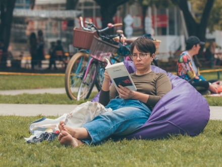 Mujer leyendo sentada en el Pícnic Literario. Foto: Cristhian Pérez / Idartes.