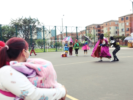 Familias disfrutando de la presentación del Programa Nidos en un parque de Bogotá