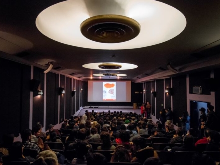 Recinto lleno. Los espectadores aprecian la proyección de un contenido sobre la pantalla.