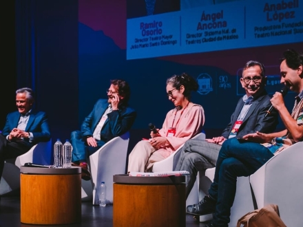 Personas sentadas en panel en un escenario