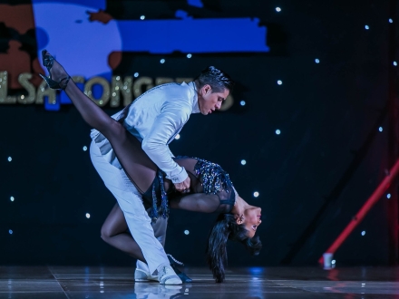 Pareja de salsa bailando en el escenario