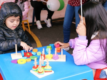 Niña y niño jugando con bloques de madera