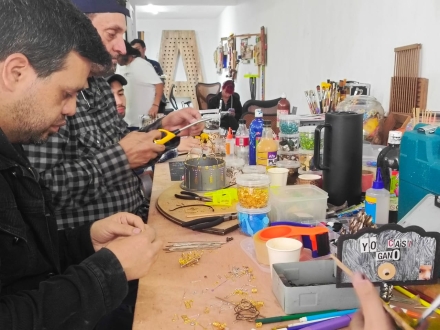 Hombres trabajando con materiales reciclados en una mesa 