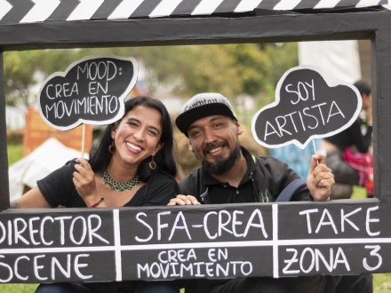 dos personas sonrien mientras sostienen un fotografama de cine gigante. Fotografía por Lina Pachón