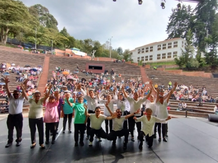 un grupo de adultos mayores en la tarima del teatro al aire libre la media torta