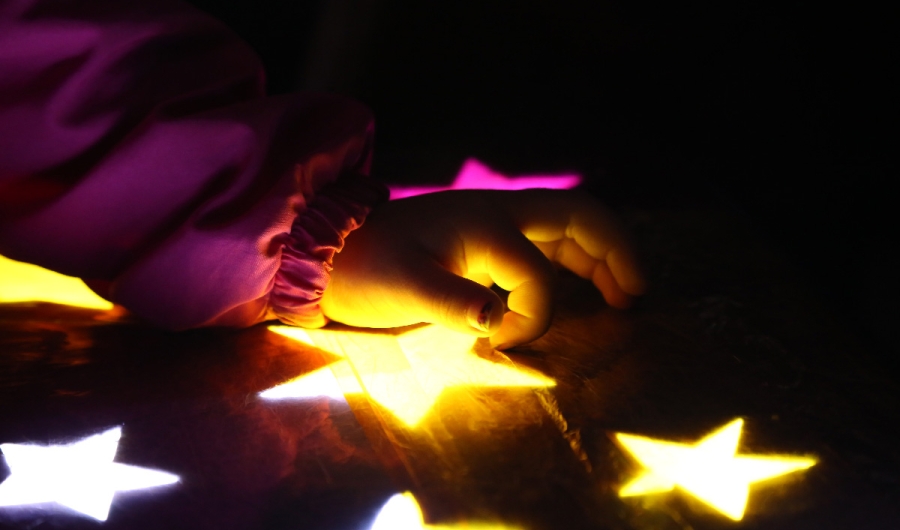 Mano de niño jugando con estrellas iluminadas