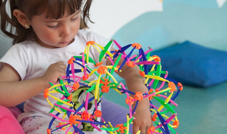 Niña jugando con estrella de colores vivos.