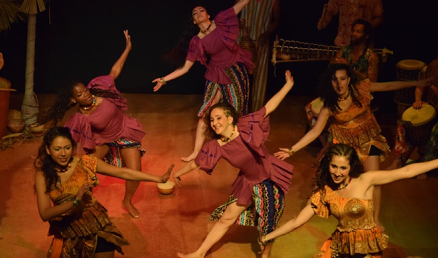 Bailarines danzando en el escenario con trajes coloridos