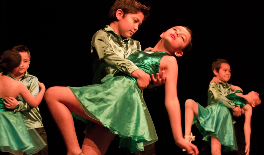 Niños bailando con trajes verdes