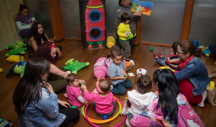 Mujeres y niños participando de una actividad lúdica e instructiva.