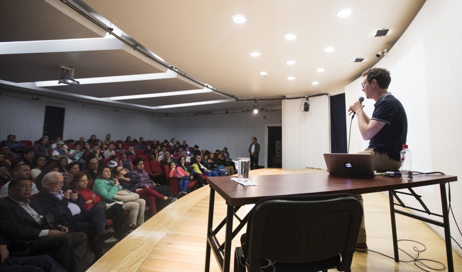 Hombre dando una conferencia en un salón con público