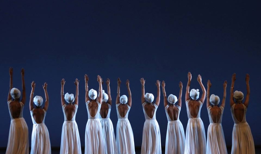 Bailarinas con trajes blancos de falda larga y sombrero danzando.