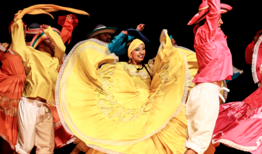 Hombres y mujeres danzando con vestidos coloridos y alegres