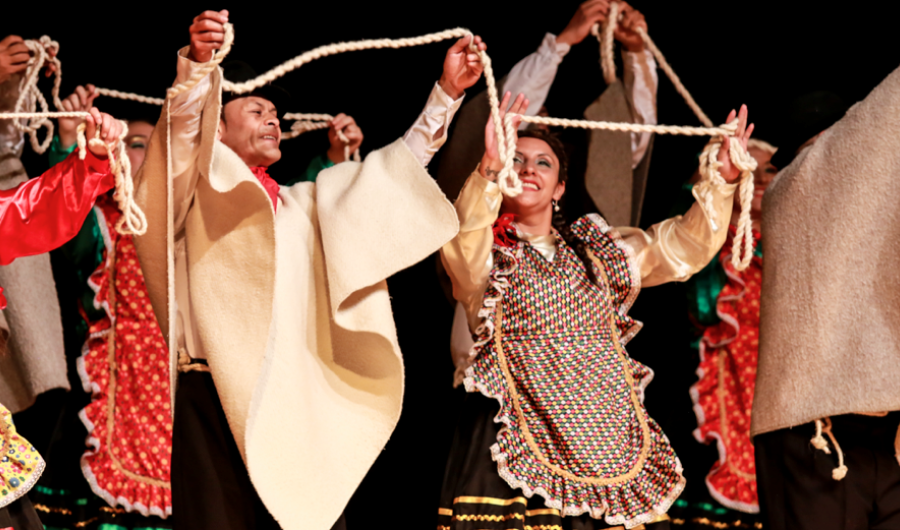 Bailarines con trajes típicos y ruanas en escena