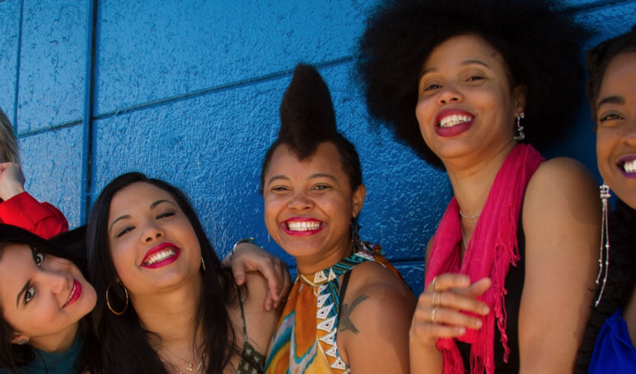 Mujeres sonriendo para la cámara sobre un fondo azul