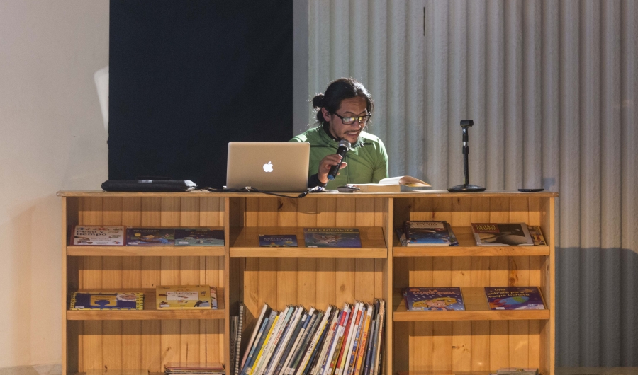 Hombre en una bibliotreca leyendo para el público