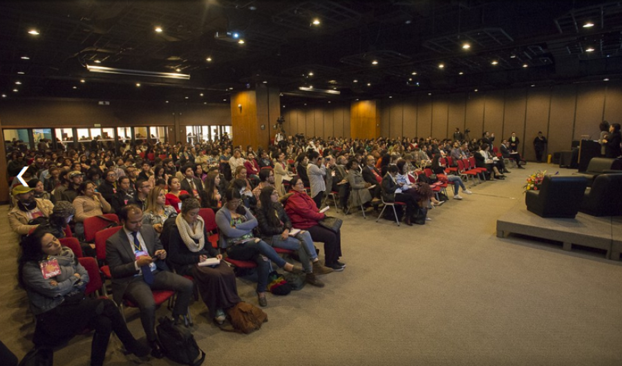 Personas participamdo de una conferencia en un salón de la Biblioteca Luis Ángel Arango