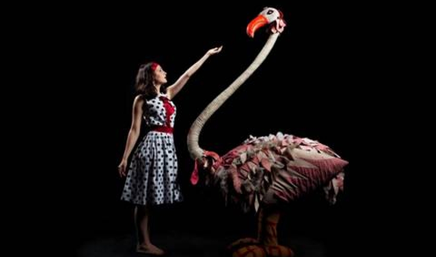 Mujer en escena con gigante cisne de fantasía