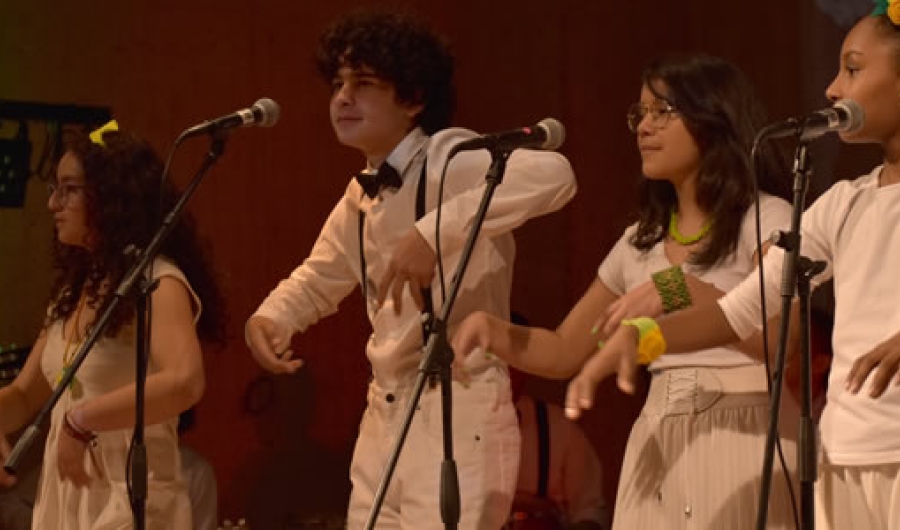 Grupo de jóvenes en escena vestidos de blanco