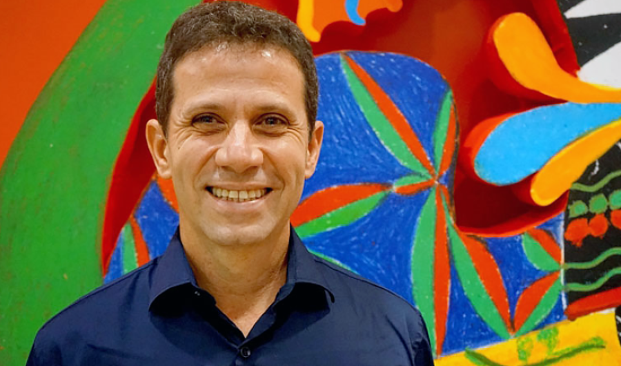 Roger Mello sonriendo con fondo de colores