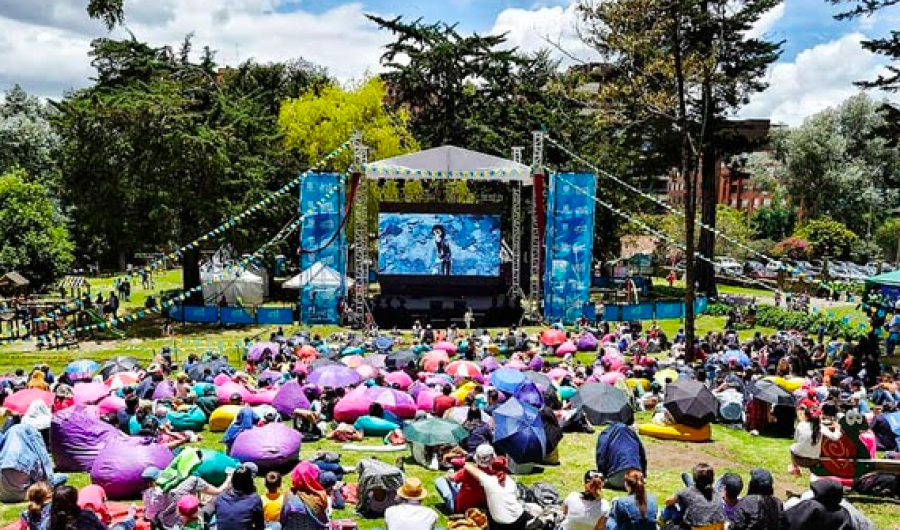 grupo de personas sentadas en el parque viendo películas 