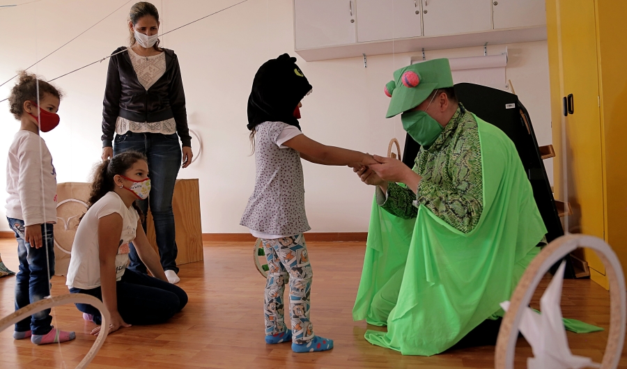 Artista del Programa Nidos que juega con niñas y niños.