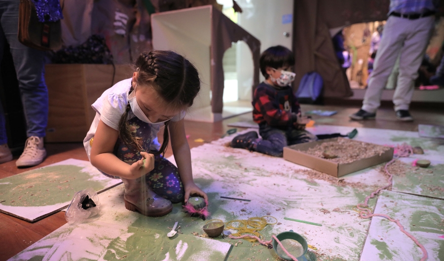 Niña y niño jugando con materias y materiales en ambientación efímera